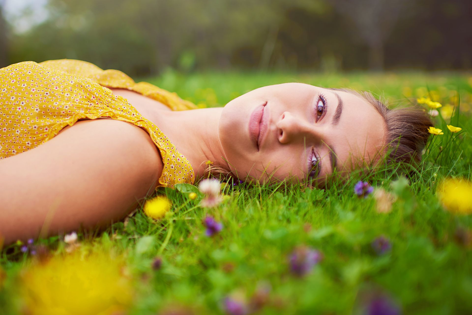 Anti-Stress-Therapie Berlin: Frau liegt entspannt in einer Blumenwiese für mehr innere Ruhe